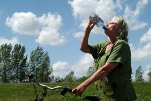 woman on bicycle drinking